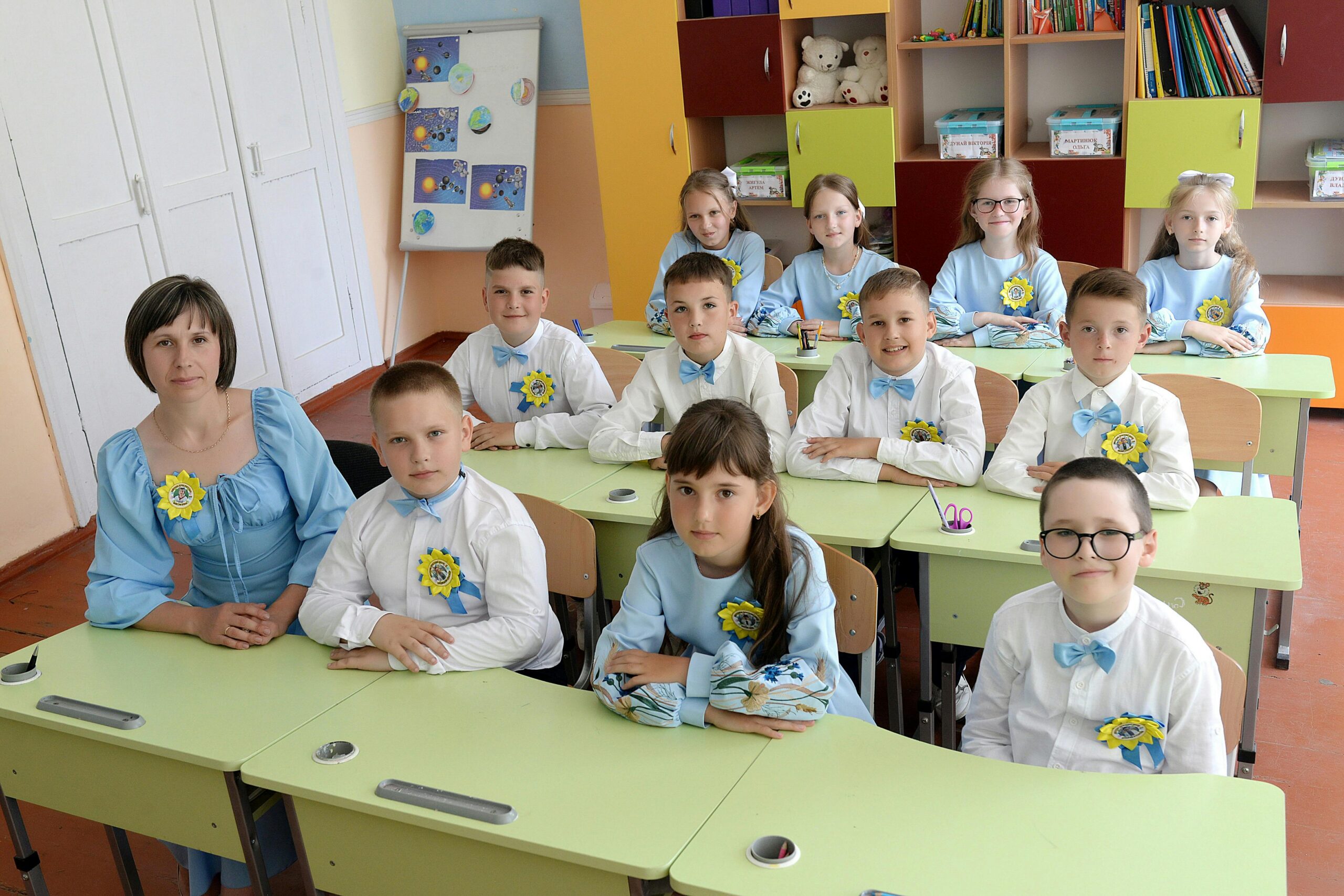 A group of elementary students sitting at desks in a bright classroom, representing the importance of indoor air quality for healthy learning environments.