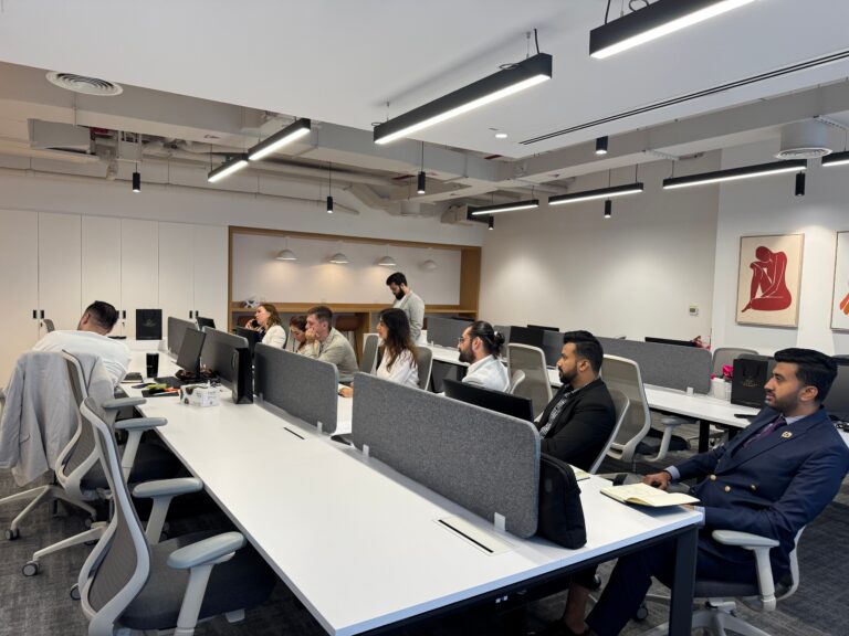 Employees working at desks in an open-plan office where indoor air quality affects focus and productivity